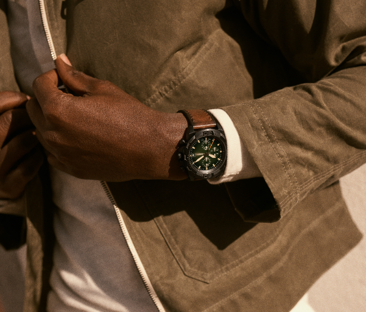 Homme élégant portant une montre Bronson de Fossil avec un bracelet en cuir vieilli brun.