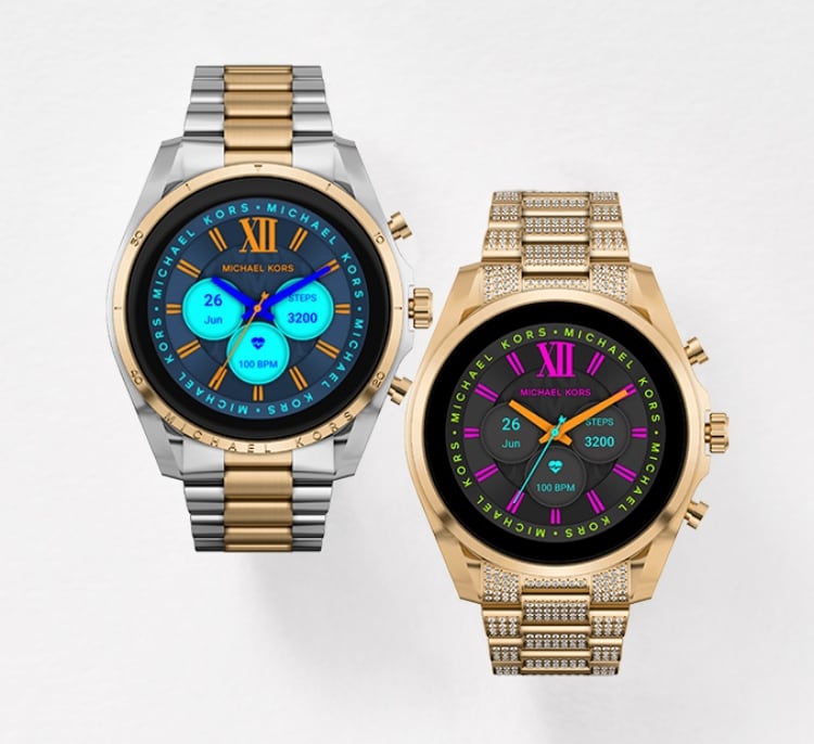 Two Michael Kors Gen 6 smartwatches in gold-tone and two-tone.