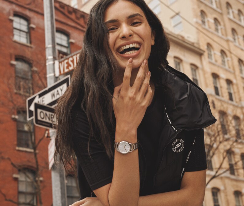 Two stylish women in a city wearing DKNY watches.