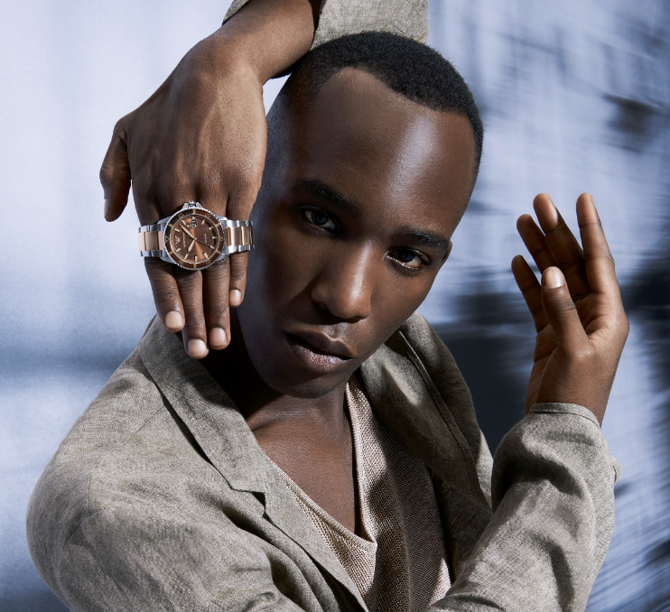 Stylish man wearing navy Emporio Armani watch. Stylish woman wearing striped Emporio Armani watch.