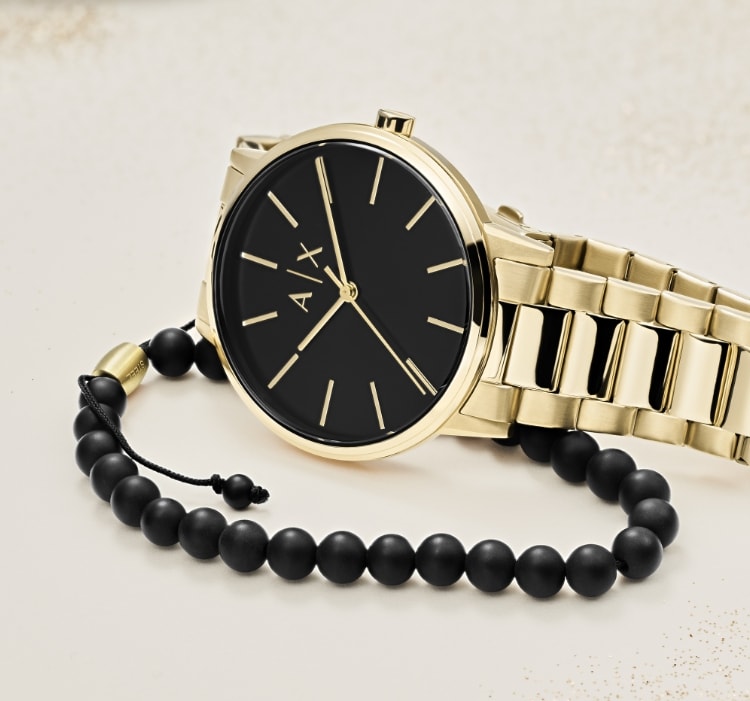 A black and gold-tone Armani Exchange watch with matching beaded bracelet.