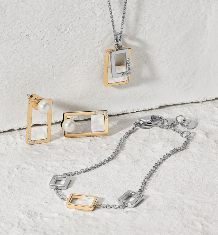 Stylish woman wearing two-tone Skagen necklace, earrings and bracelet.