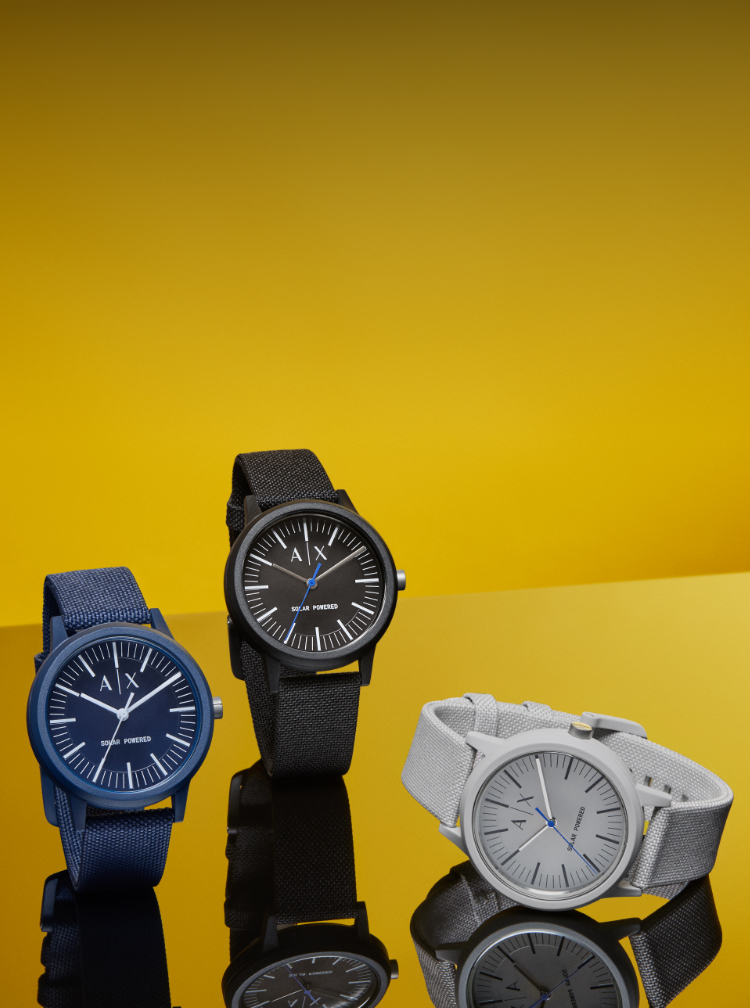 Trois montres A|X durables en bleu marine, noir et gris.