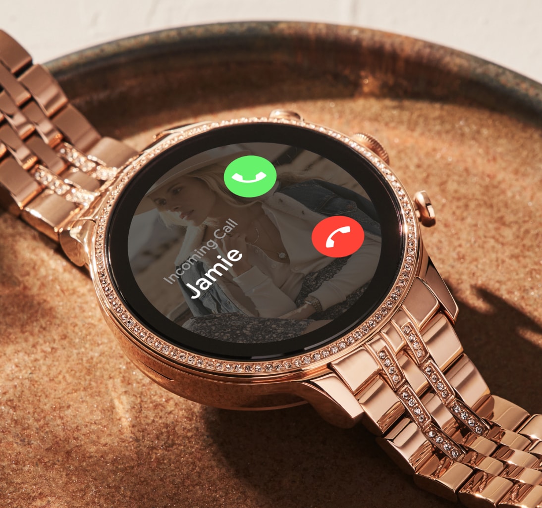 Eine Gen 6 Smartwatch aus roségoldfarbenem Edelstahl mit eingehendem Anruf auf dem Zifferblatt. Eine Gen 6 Smartwatch aus roségoldfarbenem Edelstahl mit eingehendem Anruf auf dem Zifferblatt.