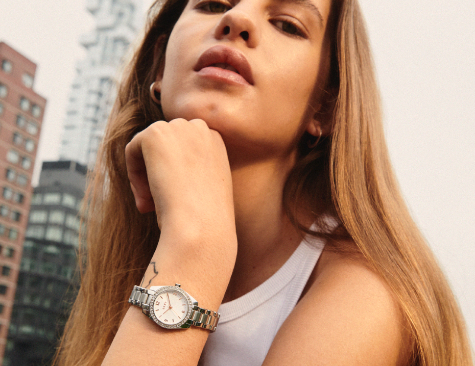 Two stylish women in a city wearing DKNY watches.