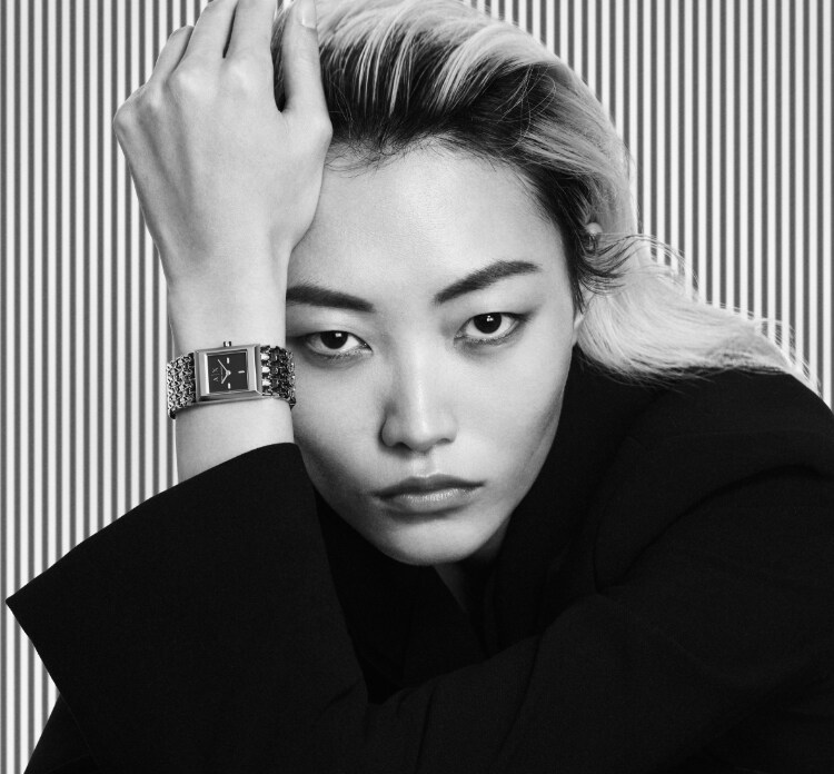 Modern, stylish woman wearing black and white A|X watch.