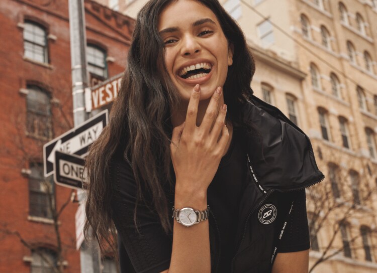 Two stylish women in a city wearing DKNY watches.