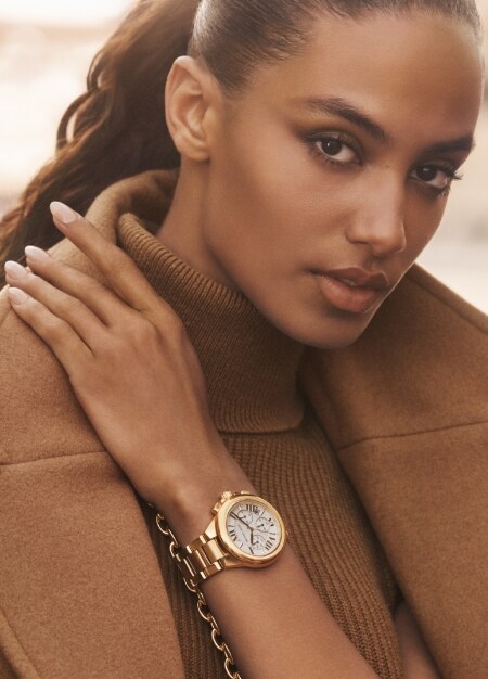 Woman wearing new golden watch style from Michael Kors