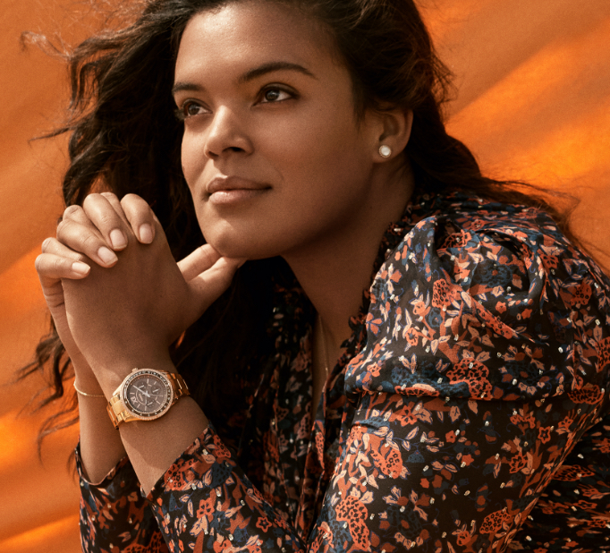 Femme élégante portant une montre Stella de Fossil doré rose.