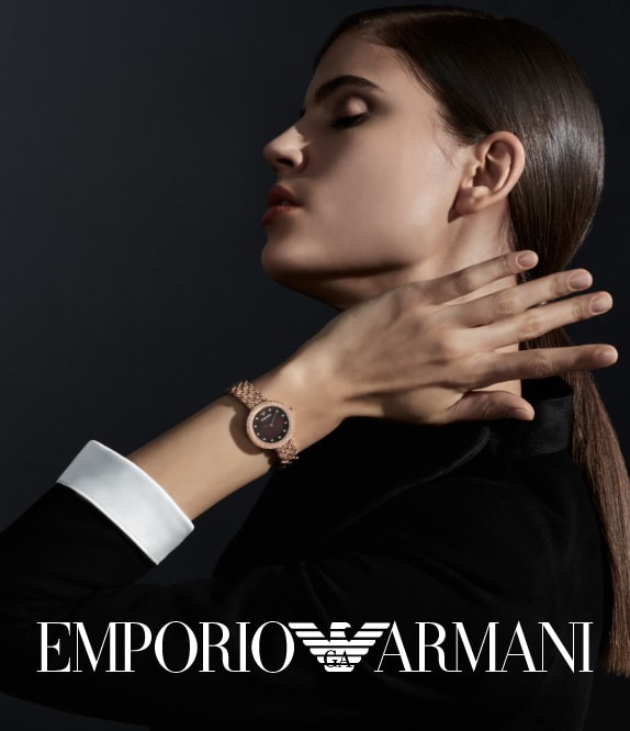 Modern woman wearing Emporio Armani watch in rose gold-tone with a glitz topring and brown dial.