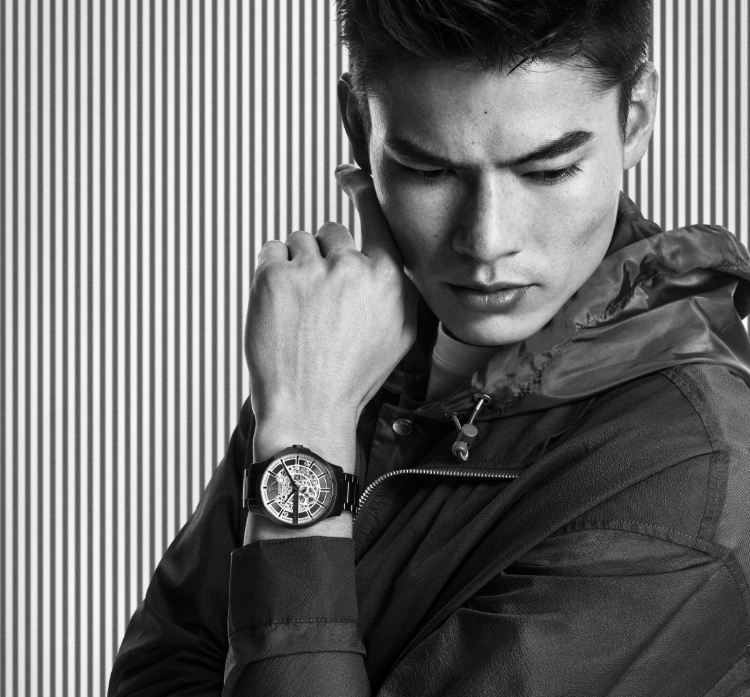 Modern, stylish man wearing a black and white A|X watch.