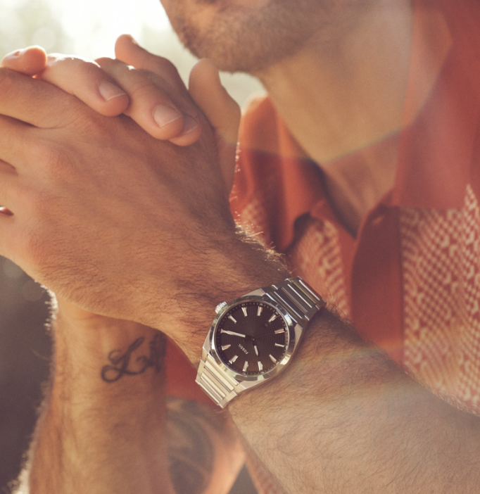 Man wearing stainless Everett watch featuring black dial.